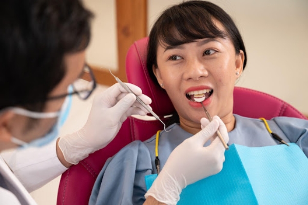 Bác sĩ kiểm tra tình trạng răng miệng cho bệnh nhân